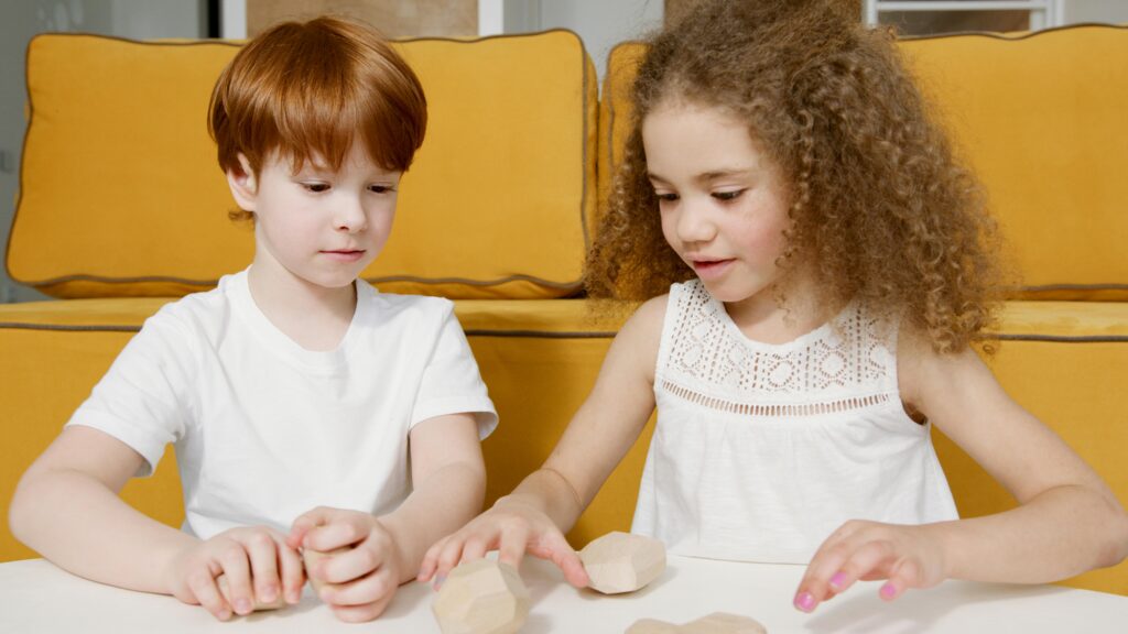 pexels-photo-6951607-6951607 Two children having fun with wooden toys indoors, fostering creativity and play.